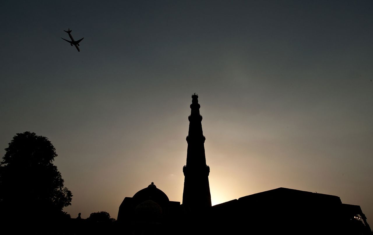 A plane flies over the Qutub Minar, New Delhi, June 19, 2012
