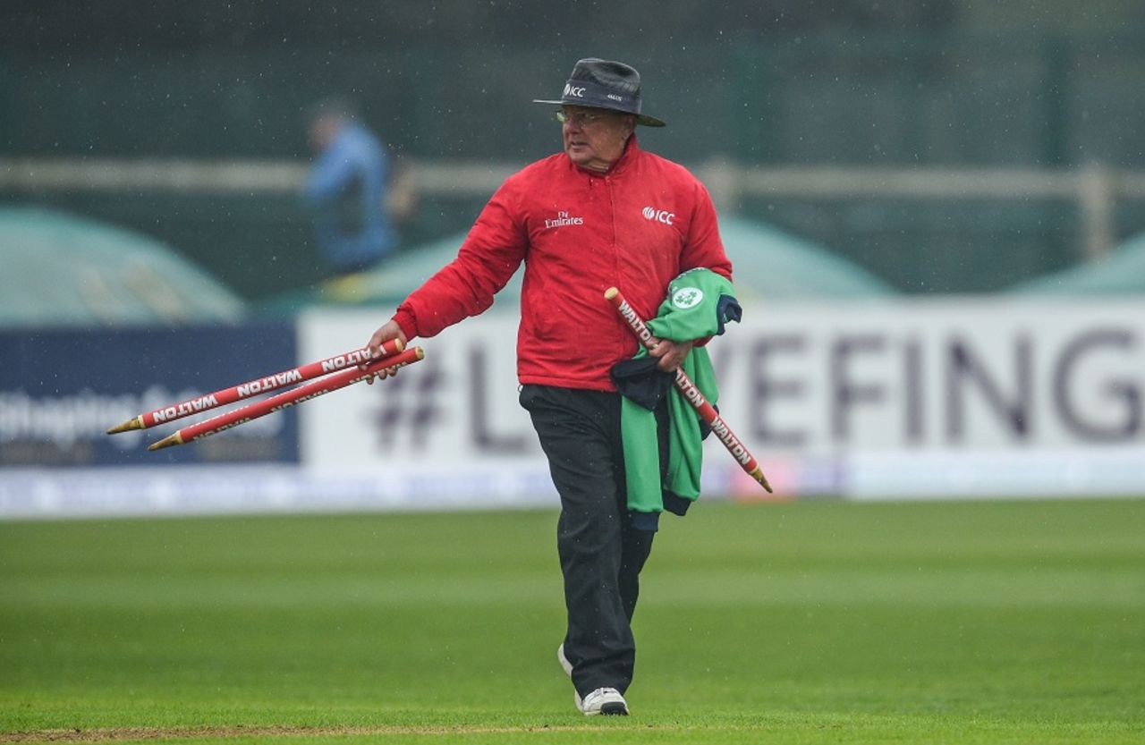 Umpire Ian Gould walks off with the stumps after rain interrupts play, Ireland v Bangladesh, tri-nation series, Malahide, May 12, 2017