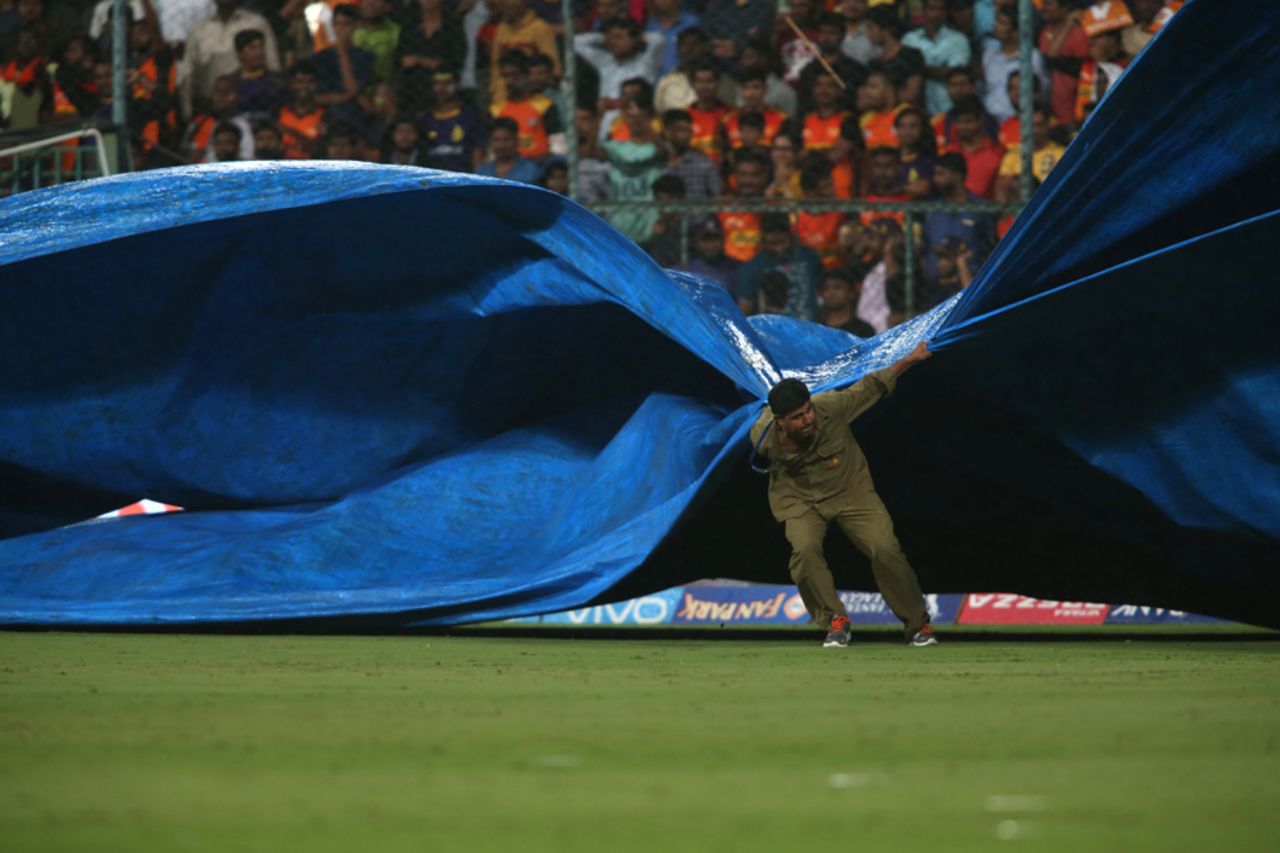 A groundsman at the M Chinnaswamy Stadium brings the covers on as rain started to fall , Sunrisers Hyderabad v Kolkata Knight Riders, Eliminator, IPL 2017, Bangalore, May 17, 2017