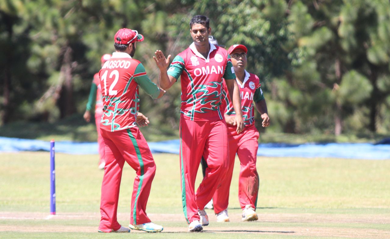 Khawar Ali gets high-fived after taking the wicket of Ibrahim Khaleel, Oman v USA, ICC World Cricket League Division Three, Entebbe, May 23, 2017