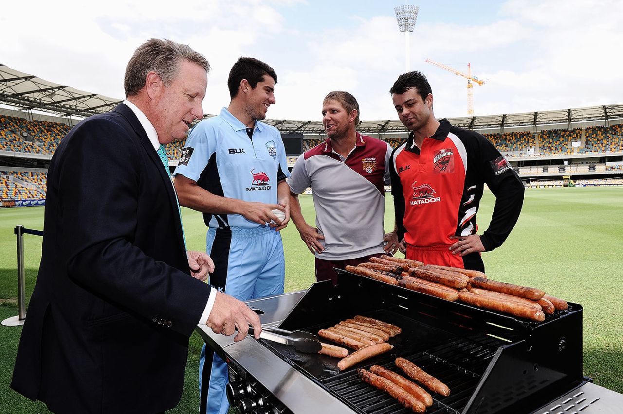 Moises Henriques, James Hopes and Callum Ferguson watch Ian Healy cook sausages, Brisbanem October 2, 2014