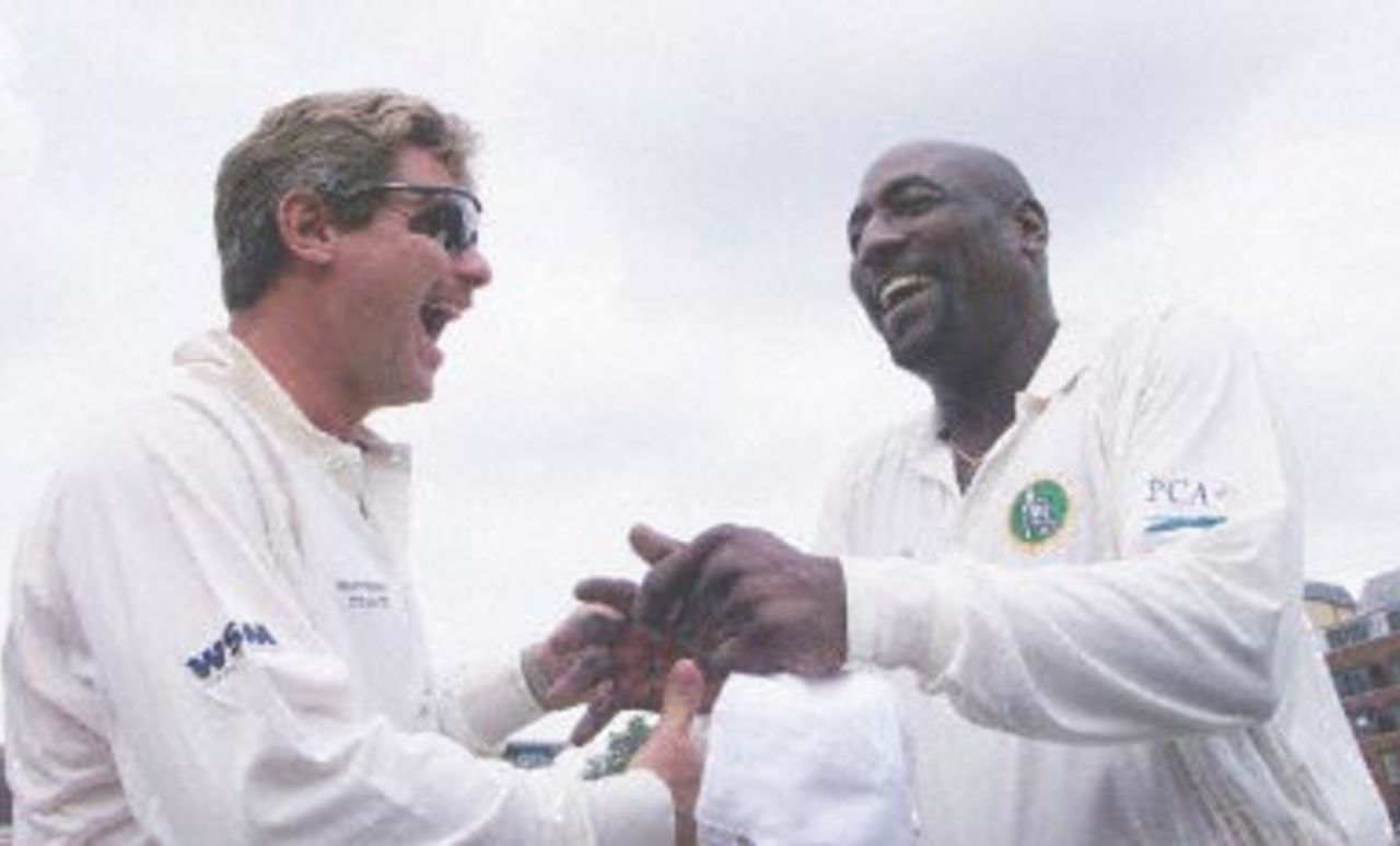 Robin Smith (L) and Viv Richards ex-captain of the West Indies cricket team enjoy a joke after the toss up for the Malcolm Marshall memorial cricket match at the Honorable Artillery Company cricket ground in London 27 July 2000. The match is being played in honor of Malcolm Marshall the West Indies fast bowler who died of cancer last year to raise money for his widow and son.