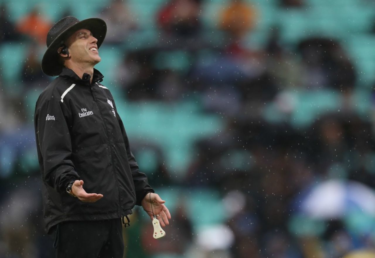 Umpire Chris Gaffaney smiles as rain comes down 24 balls before a completed game Australia v Bangladesh, Champions Trophy 2017, The Oval, London, June 5, 2017