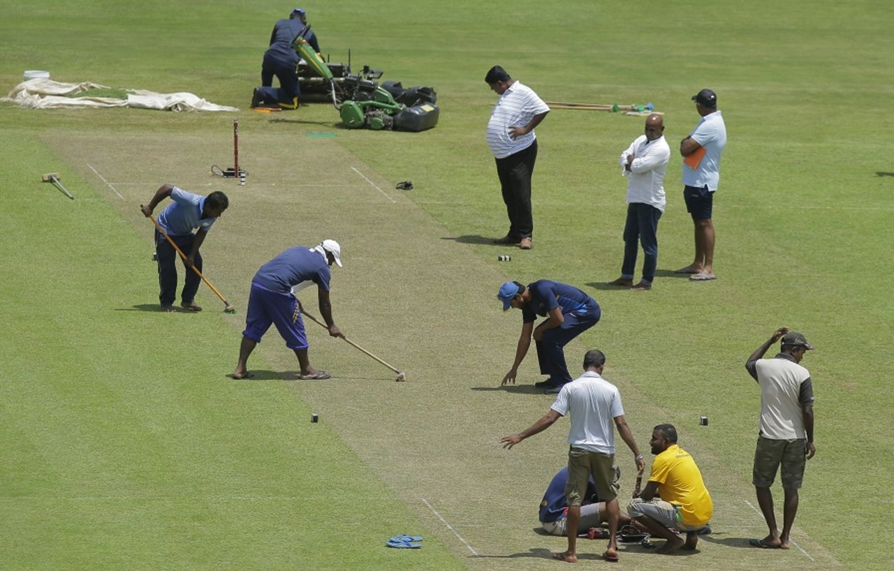 Sri Lanka captain Dinesh Chandimal inspects the pitch even as the groundstaff works on it, Pallekele, August 11, 2017
