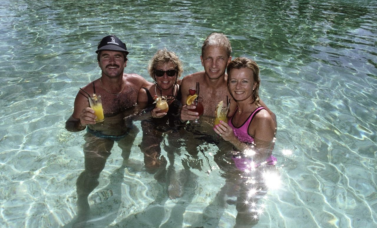 Allan Lamb and David Gower relax in a pool with their partners, 1990