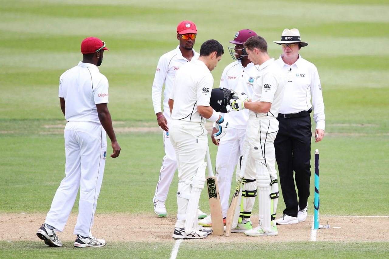 Mitchell Santner examines his helmet after being hit by a Miguel Cummins bouncer, New Zealand v West Indies, 2nd Test, Hamilton, 3rd day, December 11, 2017
