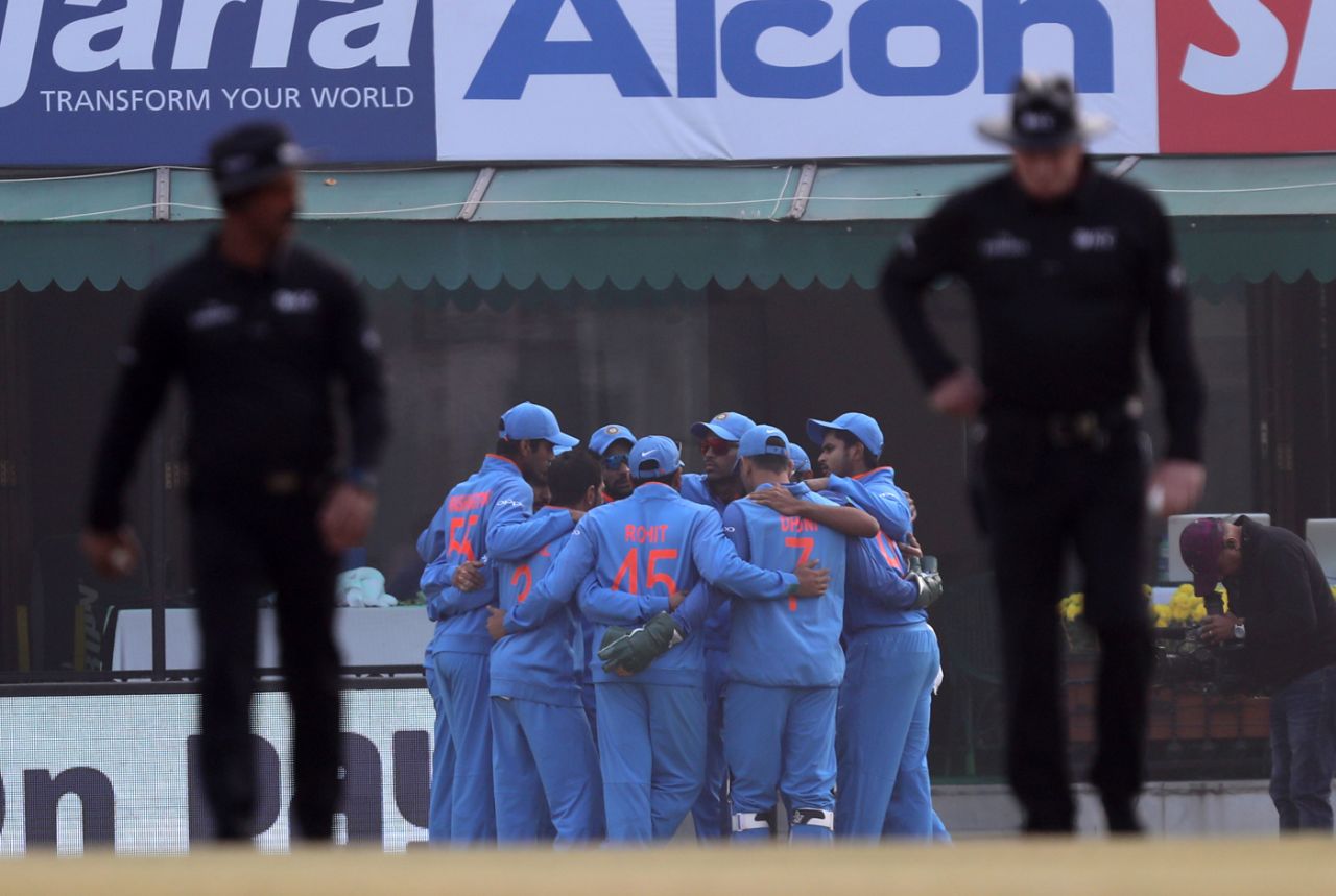 The umpires walk onto the field, past India's huddle, India v Sri Lanka, 2nd ODI, Mohali, December 13, 2017