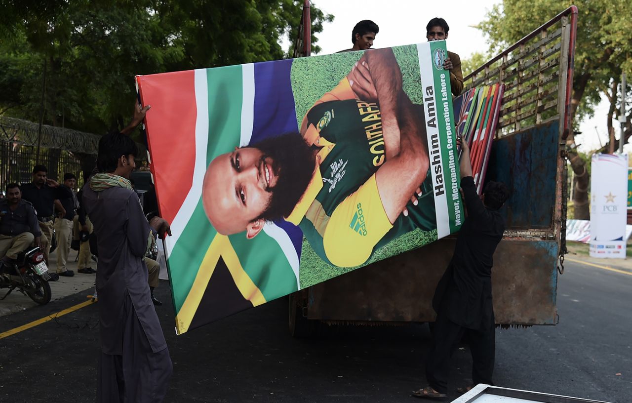 Workers carry a billboard of Hashim Amla, Lahore, September 10, 2017