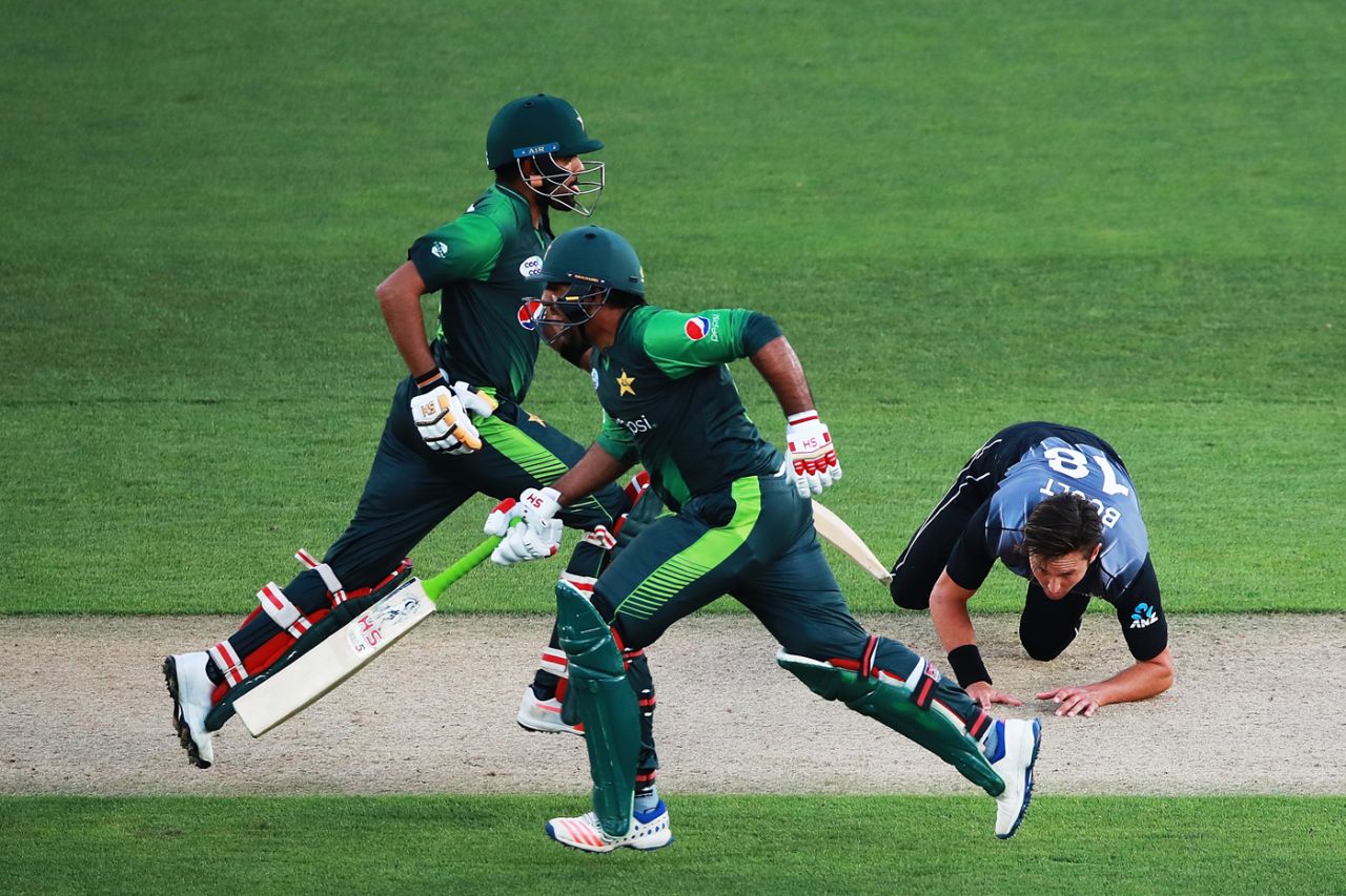Trent Boult tumbles in his follow-through as Babar Azam and Sarfraz Ahmed sneak a single, New Zealand v Pakistan, 2nd T20I, Auckland