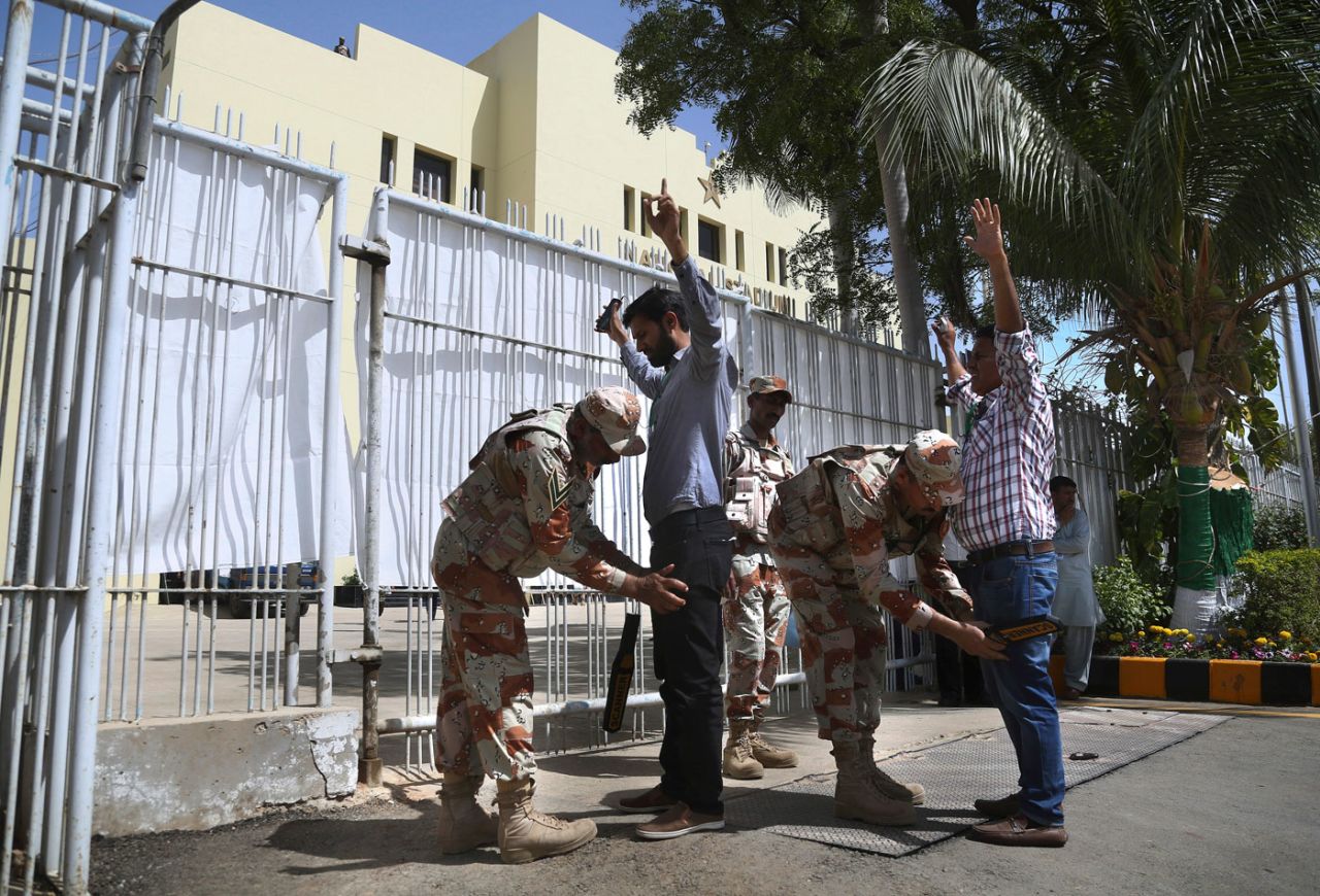 Security personnel frisk people near the entrance of the National Stadium in Karachi, Pakistan Super League, March 24, 2018