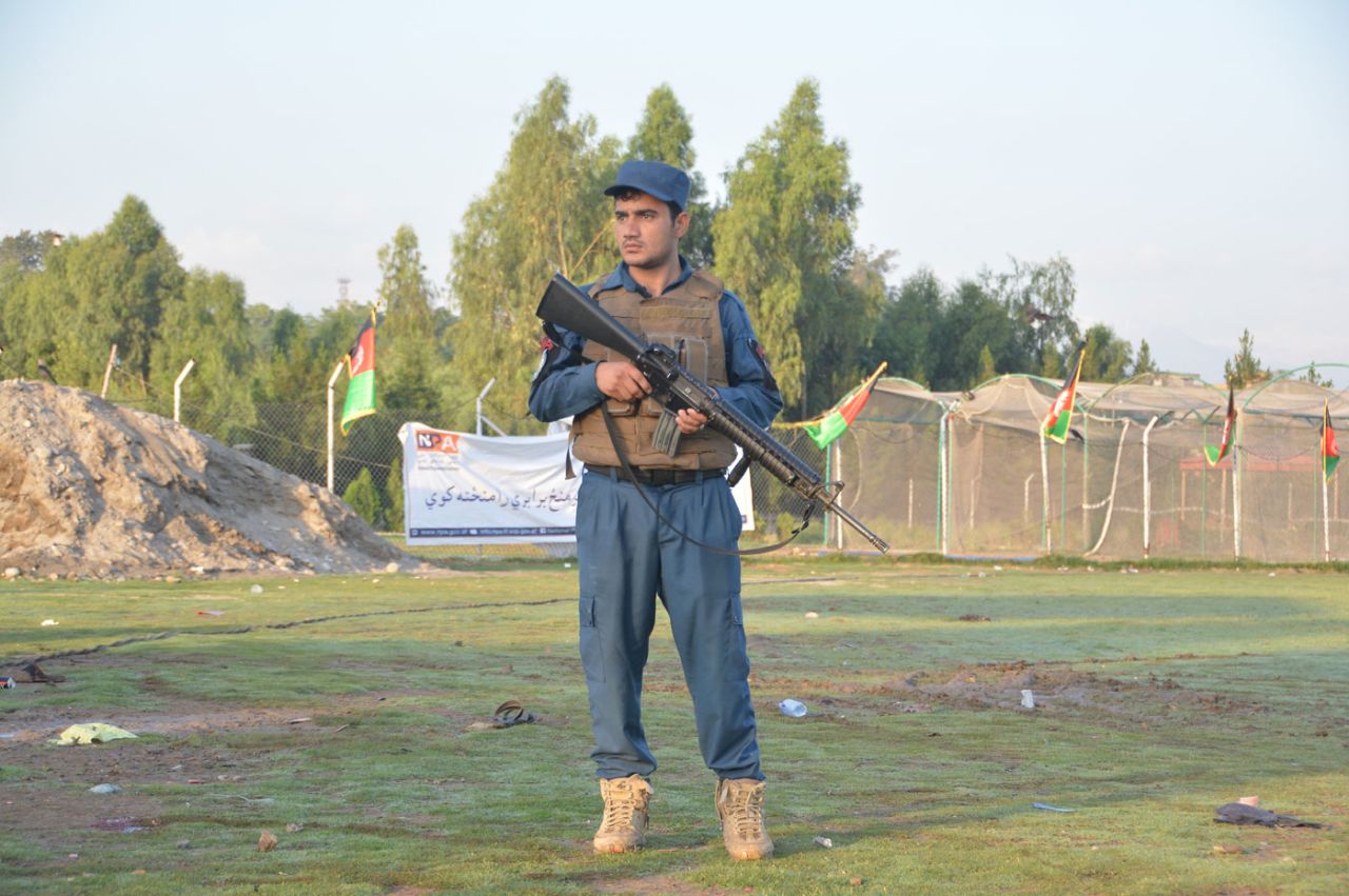 A security official stands guard at the scene of an explosion at a cricket match, Jalalabad, May 19, 2018