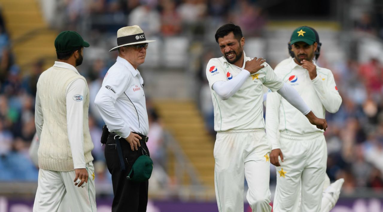 Mohammad Amir feels his shoulder after pulling up in pain