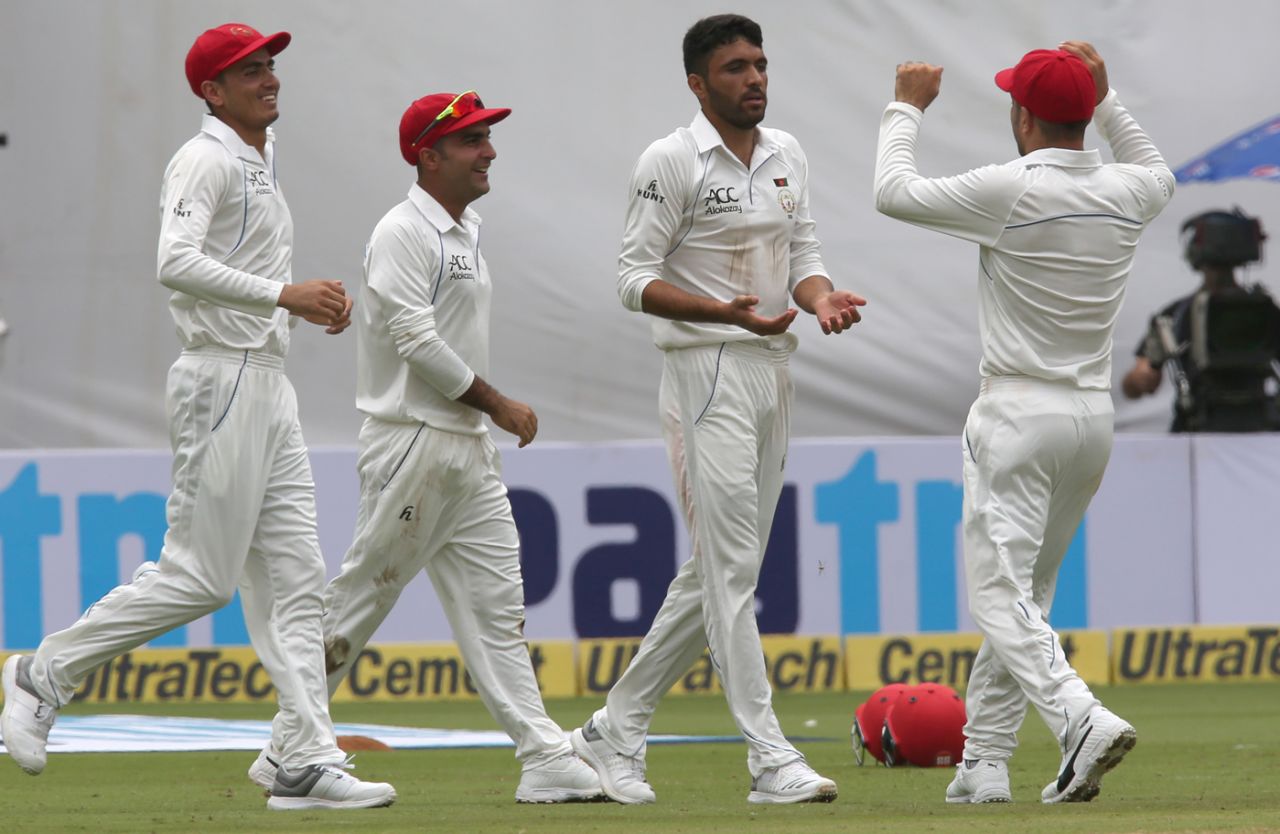 Yamin Ahmadzai is congratulated upon claiming Afghanistan's first wicket in Tests, India v Afghanistan, Only Test, Bengaluru, 1st day, June 14, 2018