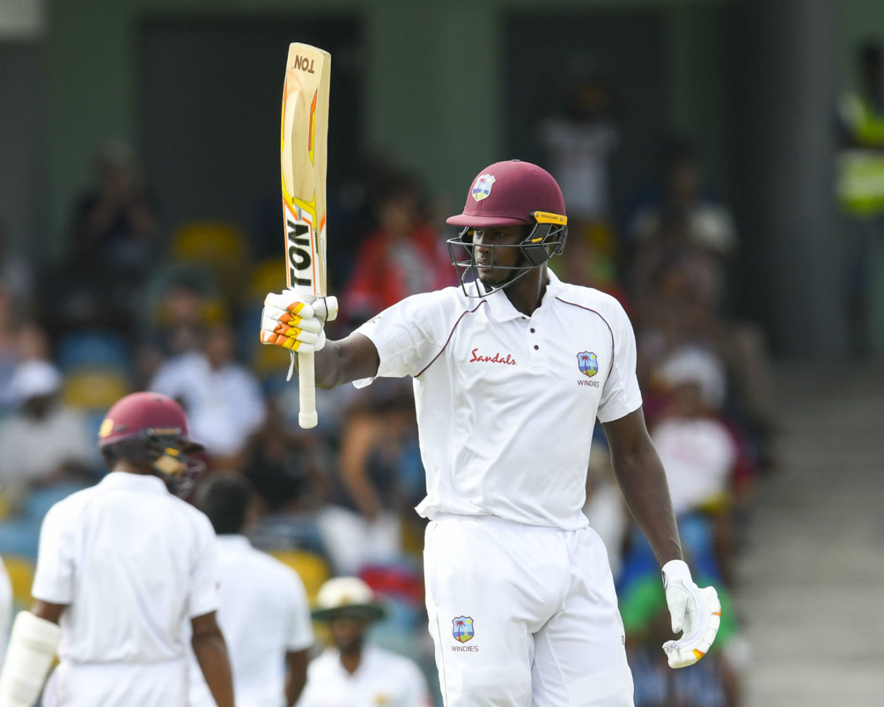 Jason Holder raises his bat after getting to his seventh Test fifty, West Indies v Sri Lanka, 3rd Test, Barbados, 2nd day, June 24, 2018