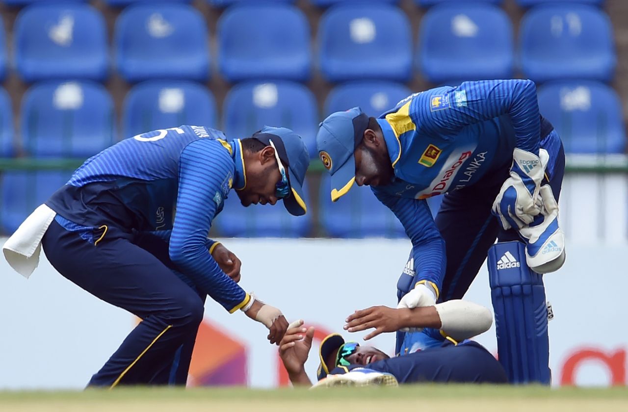 Dhananjaya de Silva and Niroshan Dickwella check on Kusal Mendis after he takes a blow to the hand at slip, Sri Lanka v South Africa, 3rd ODI, Pallekele, August 5, 2018