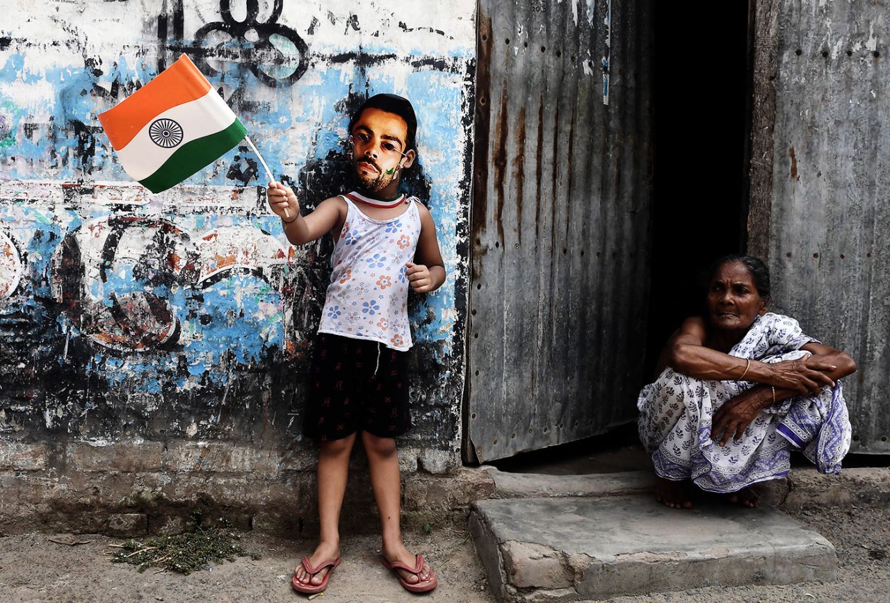 A child wears a Virat Kohli mask and waves an India flag, Kolkata, June 18, 2017
