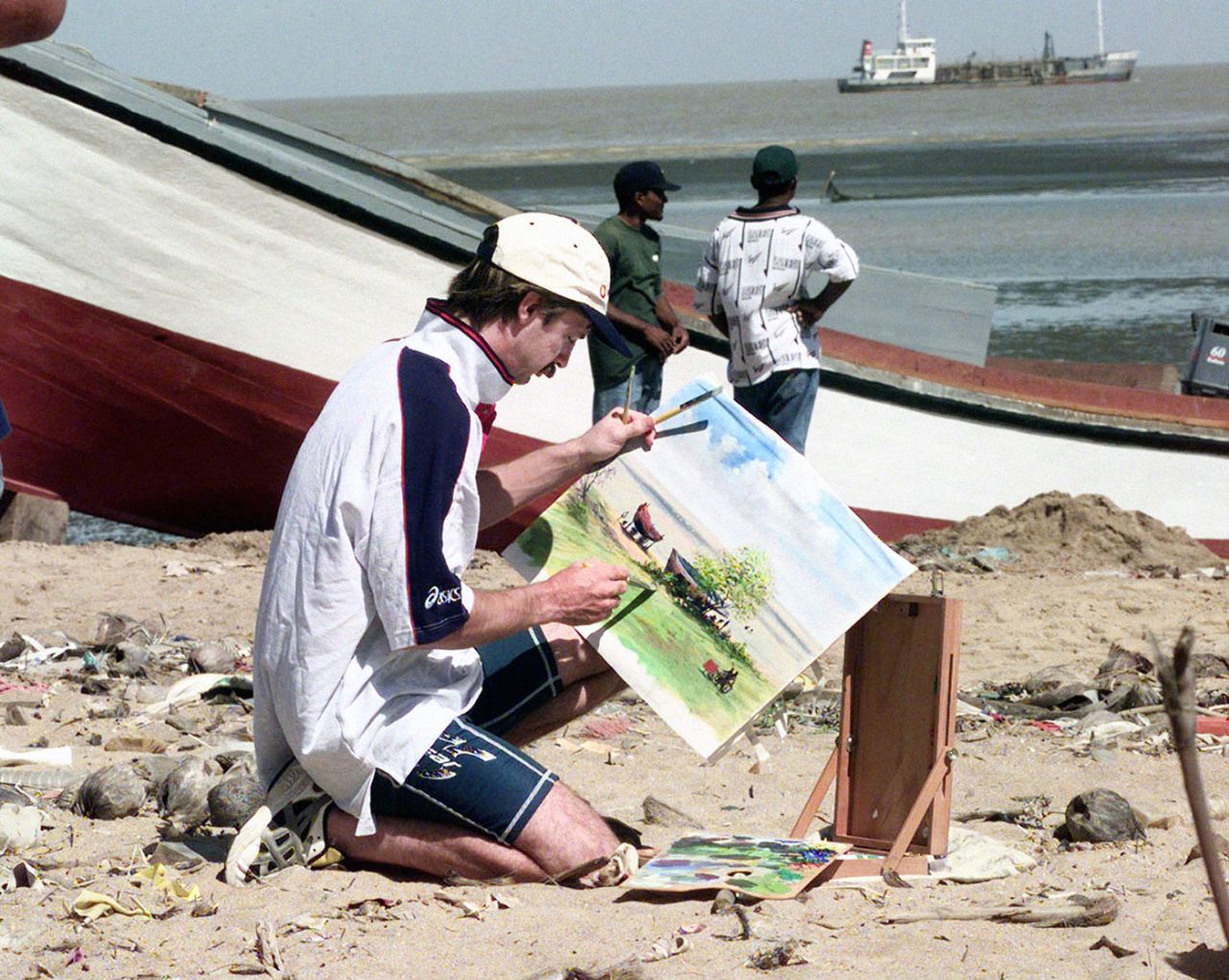 Jack Russell sits and paints on a beach in Georgetown, Guyana, February 25, 1998