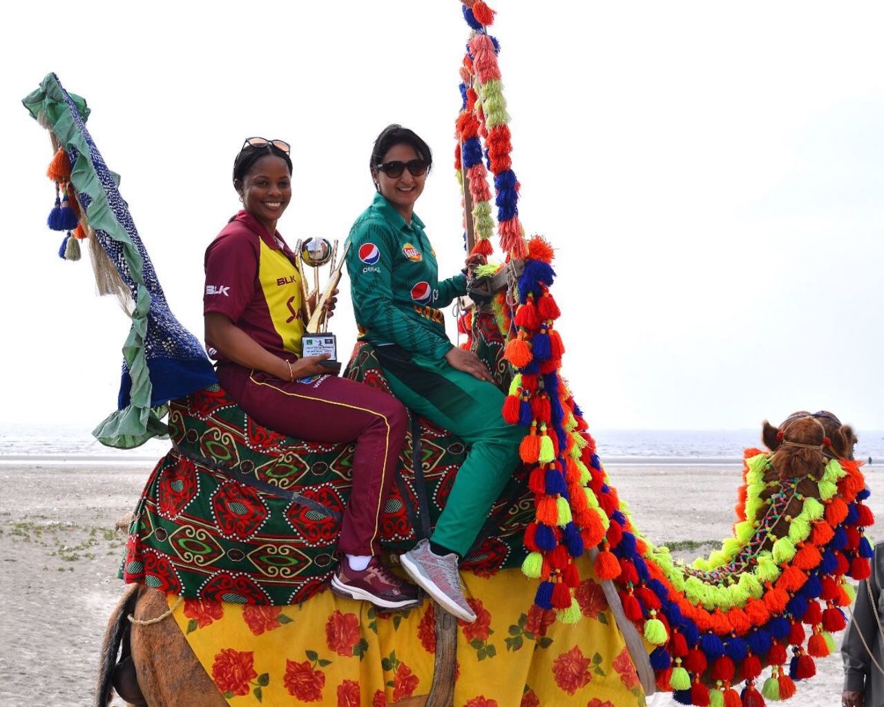Merissa Aguilleira and Bismah Maroof pose with the T20I trophy in an unusual manner, Karachi, January 30, 2019