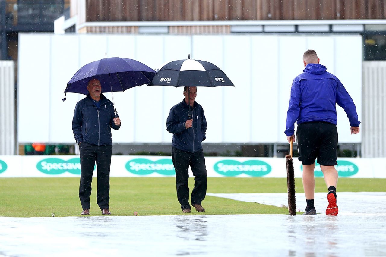 The umpires inspect the field as rain delays play on day one, Surrey v Yorkshire, County Championship Division One, Woodbridge Road, Guildford, June 10, 2019