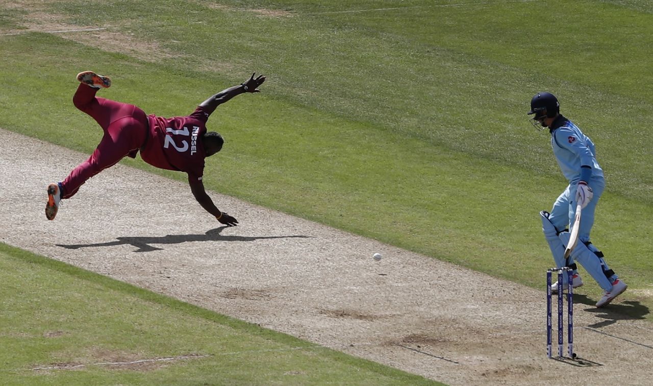 Andre Russell dives for the ball off his own bowling as Joe Root watches on, England v West Indies, World Cup 2019, Southampton, June 14, 2019