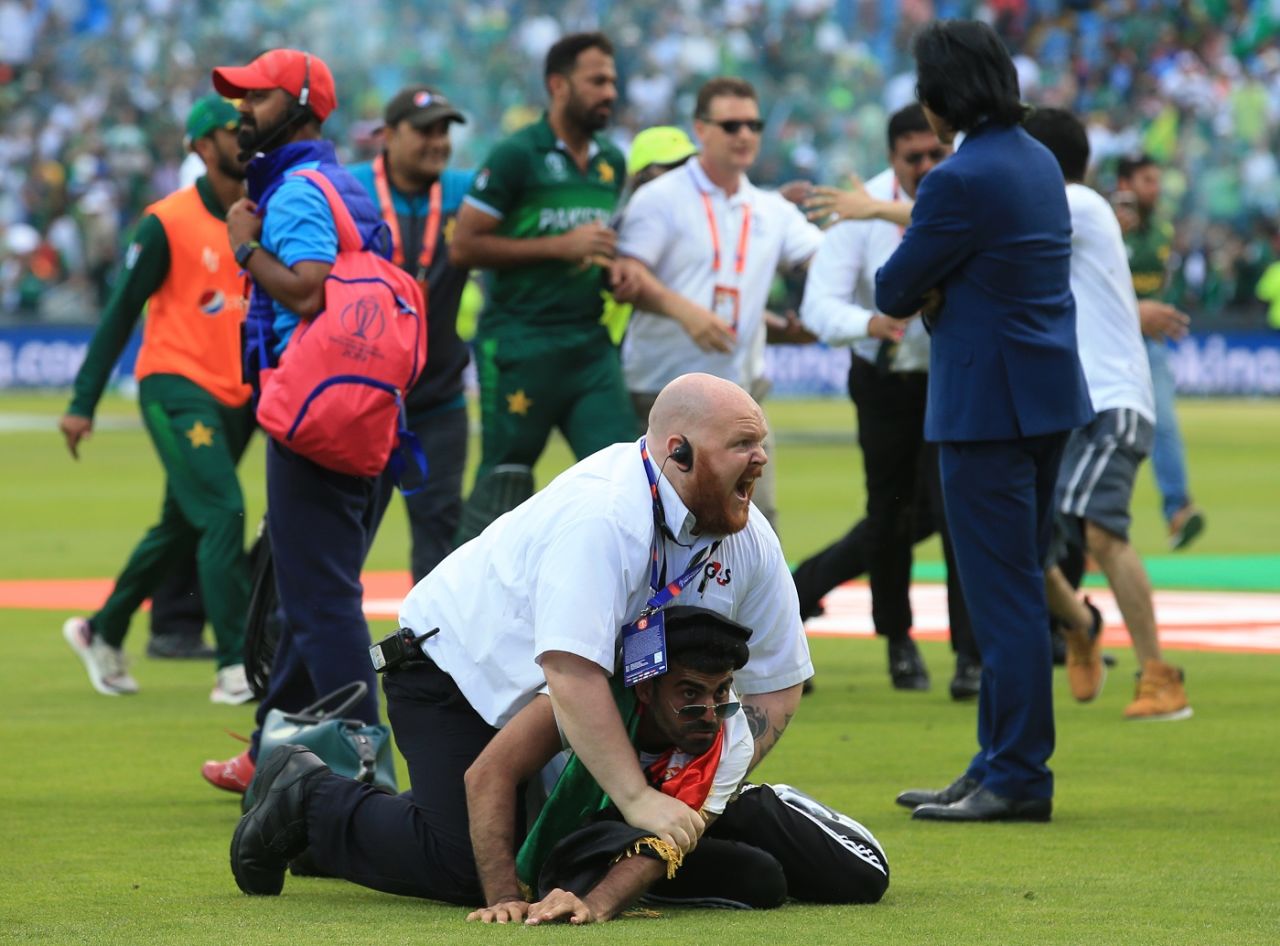 A pitch invader is tackled by a security official even as Ramiz Raja stands awaiting the players for post match interactions, Afghanistan v Pakistan, World Cup 2019, Headingley, June 29, 2019