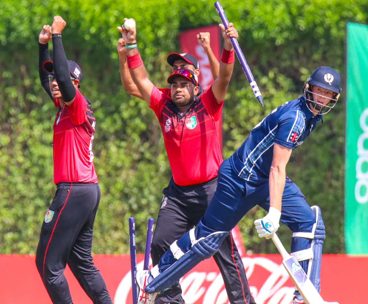 Singapore's Aritra Dutta rips out the stumps with ball in hand to end the match, Scotland v Singapore, T20 World Cup Qualifier, Dubai, October 18, 2019