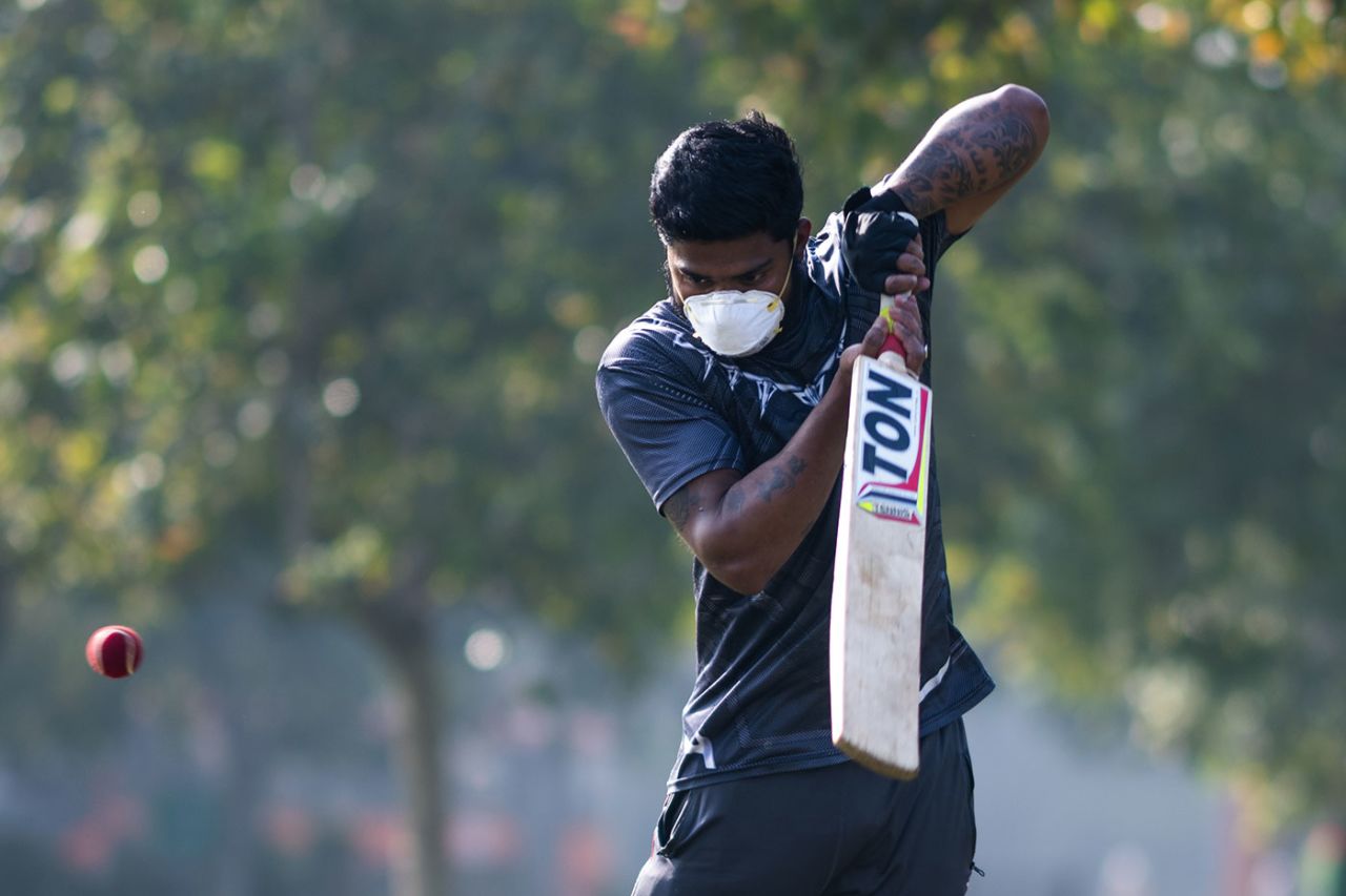 A youth plays cricket in a mask to combat COVID-19, New Delhi, March 18, 2020