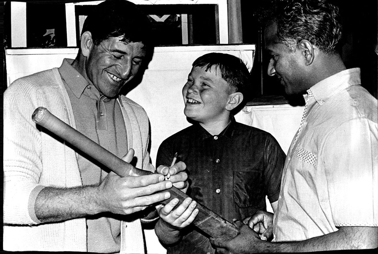 Ken Barrington (left) and Rohan Kanhai sign autographs for a boy in Sydney, October 3, 1968