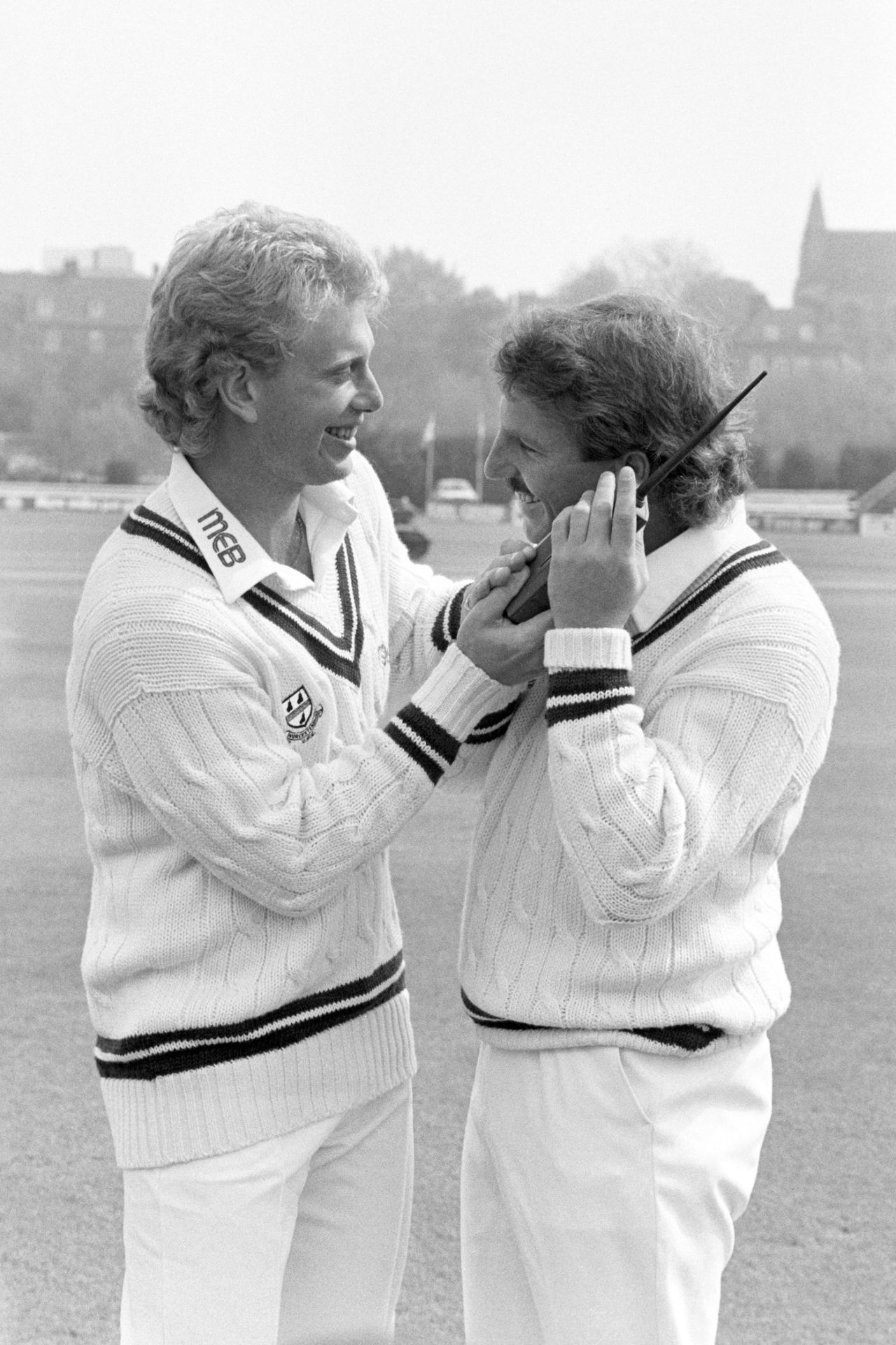 Graham Dilley and Ian Botham fool around with a mobile phone during a photo call, New Road, Worcester, April 23, 1987