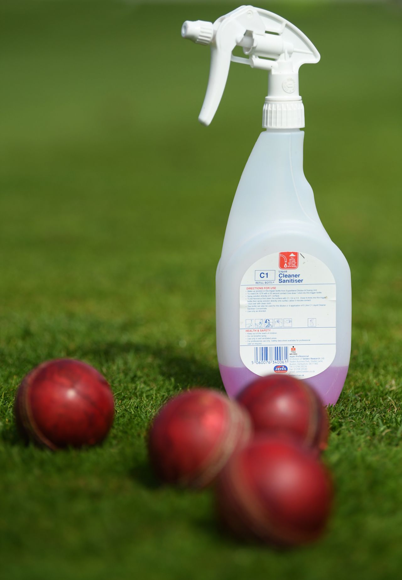 A cleaning sanitiser bottle lies next to some some balls in the outfield during a net session, County Ground, Taunton, June 15, 2020