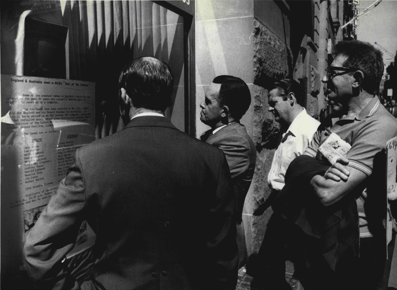 People watch the small TV set as it flashes the results of the "Computer Test" being played between Australia and England, September 23, 1971