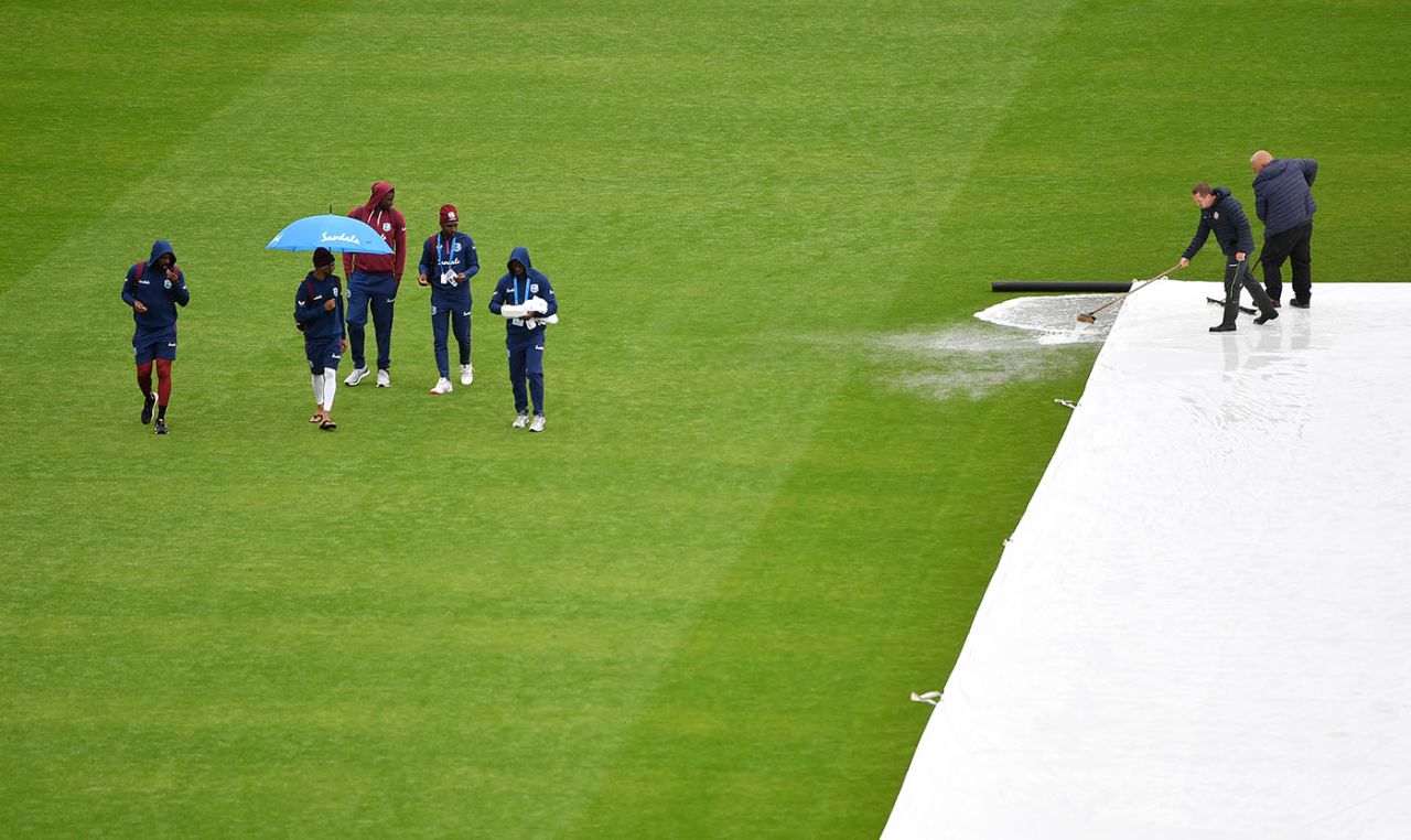 West Indies players walk across the outfield on a washed out third day at Emirates Old Trafford, England v West Indies, 2nd Test, Emirates Old Trafford, 3rd day, July 18, 2020