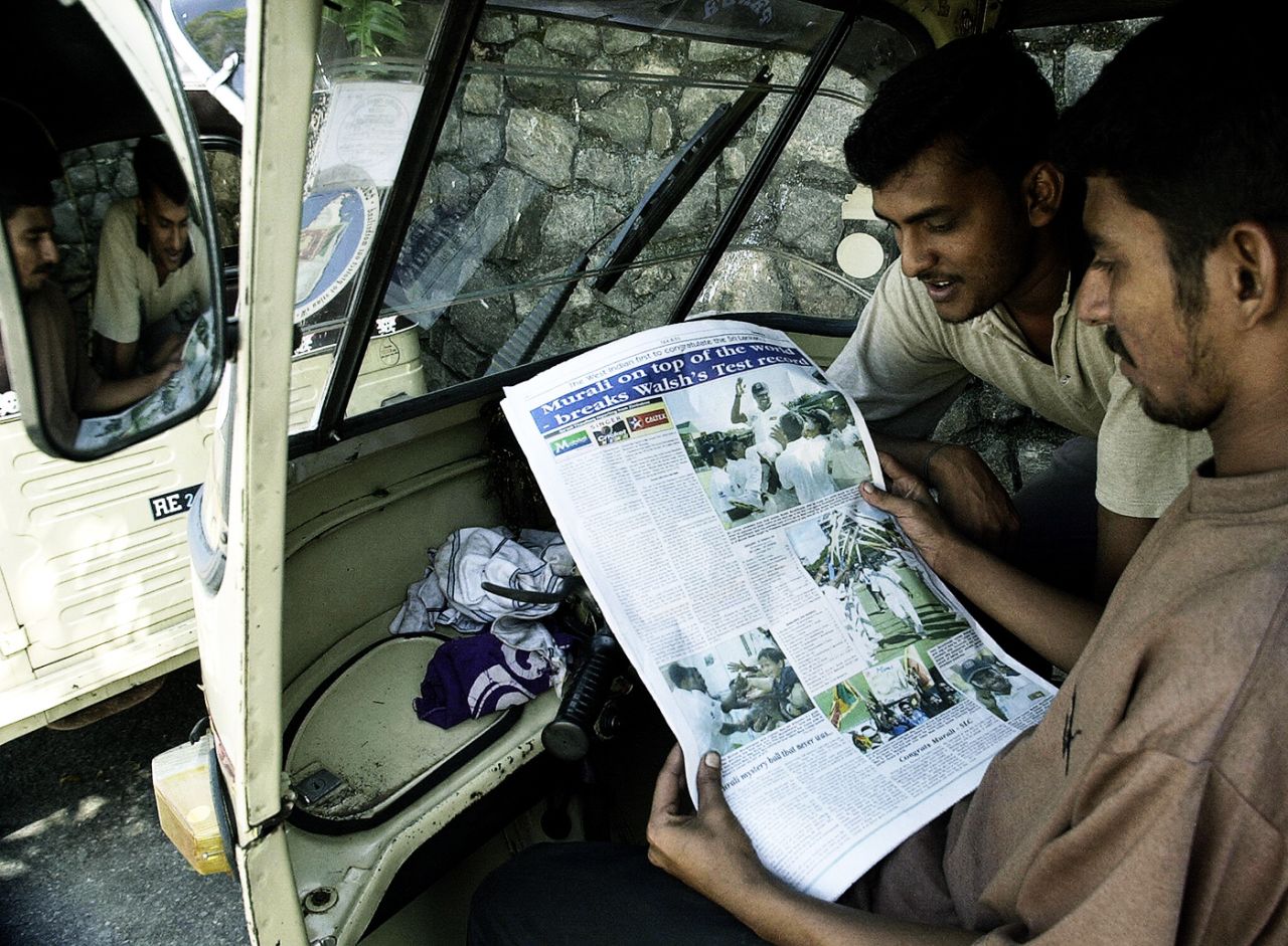 Two men in an autorickshaw read the news about Muttiah Muralitharan's new world record, Colombo, May 9, 2004