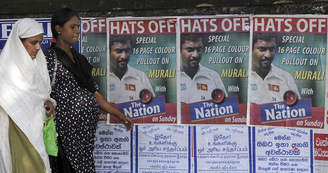 Passerbys walk past posters advertising Muttiah Muralitharan's final Test, Galle, July 17, 2010