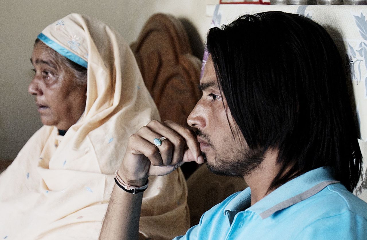 Mohammad Amir's mother and older brother Ejaz follow the sentencing process on television, Gujar Khan, Pakistan, November 3, 2011