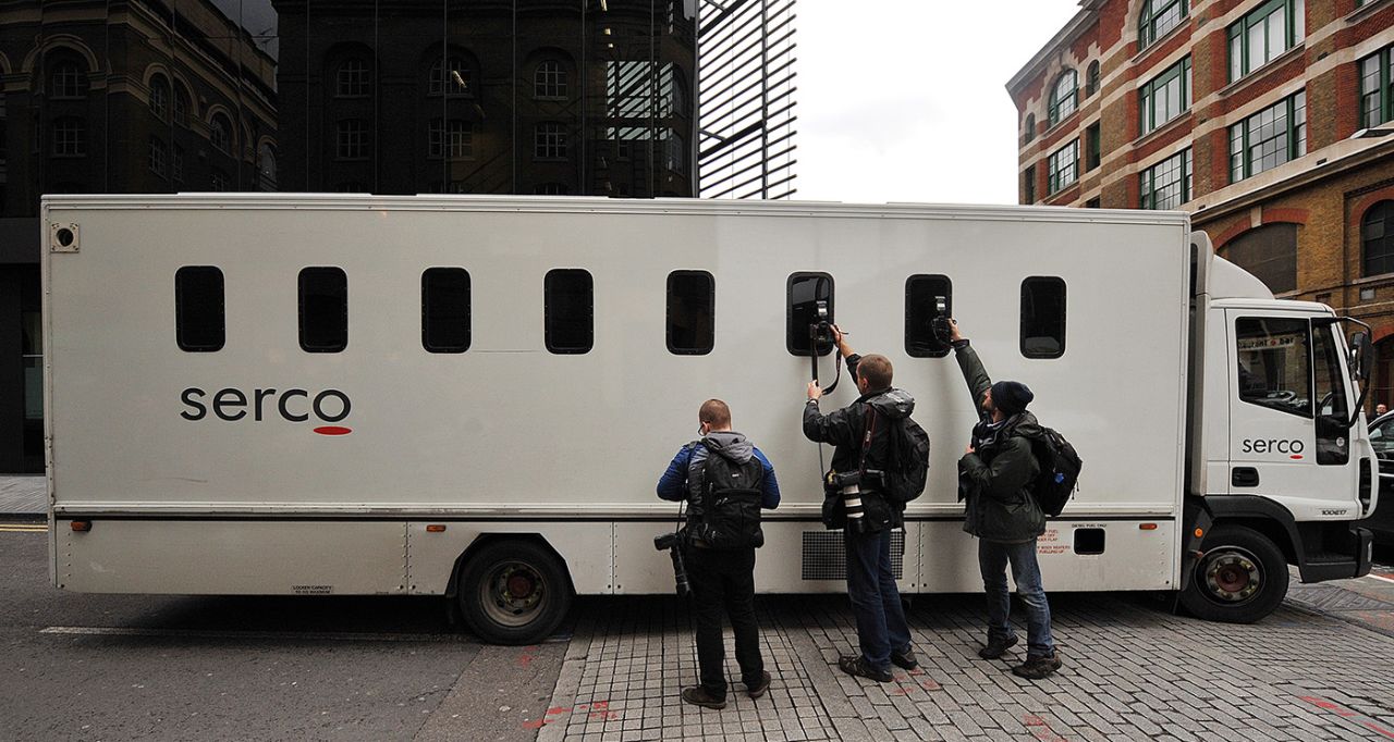 Camerapersons take photos of a prison van leaving the Southwark Crown Court, London, November 3, 2011