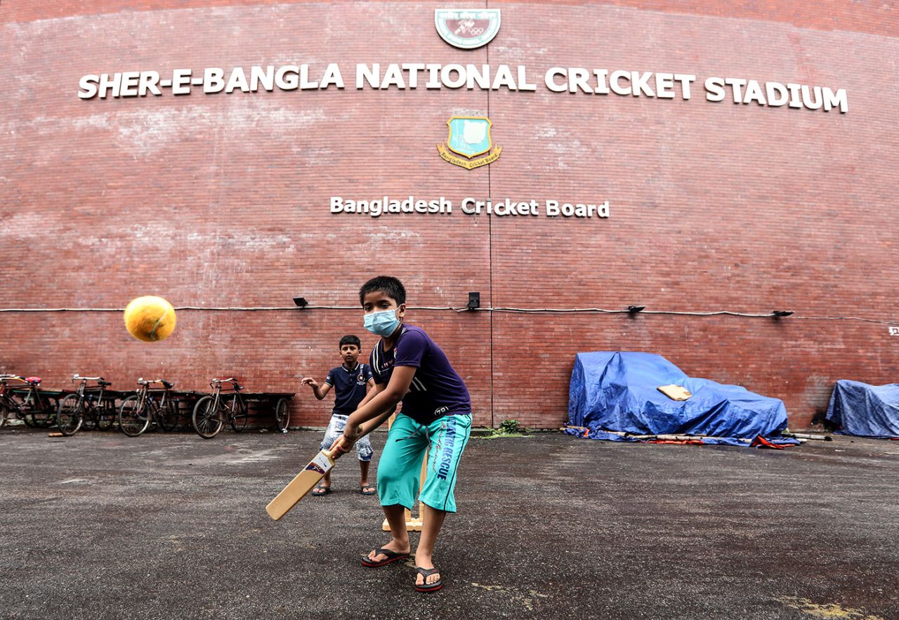 A kid in a mask plays cricket outside the Shere Bangla in Mirpur, August 16, 2020
