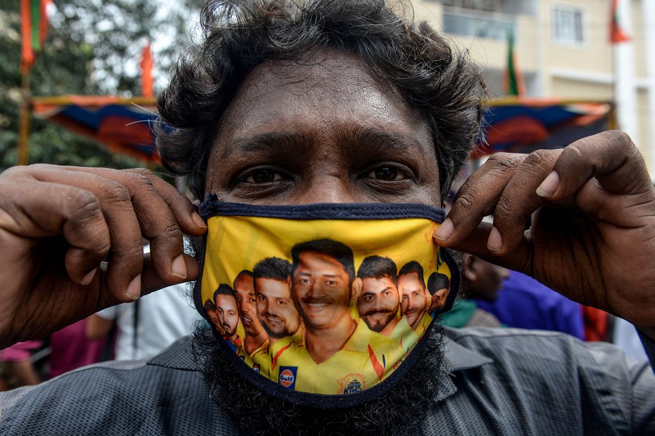 A man displays a mask featuring MS Dhoni and other Chennai Super Kings players, Chennai, September 16, 2020
