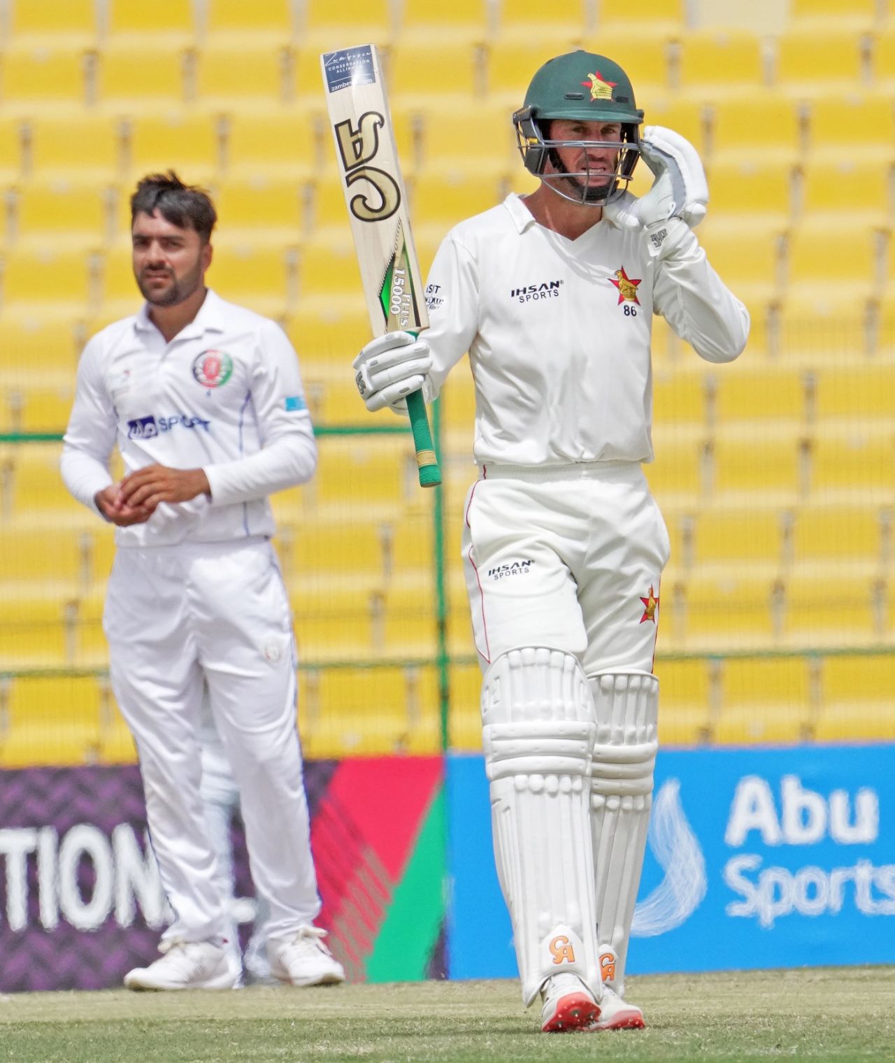 Sean Williams raises his bat after getting to 150 as Rashid Khan looks on, Afghanistan vs Zimbabwe, 2nd Test, Abu Dhabi, 5th day, March 14, 2021