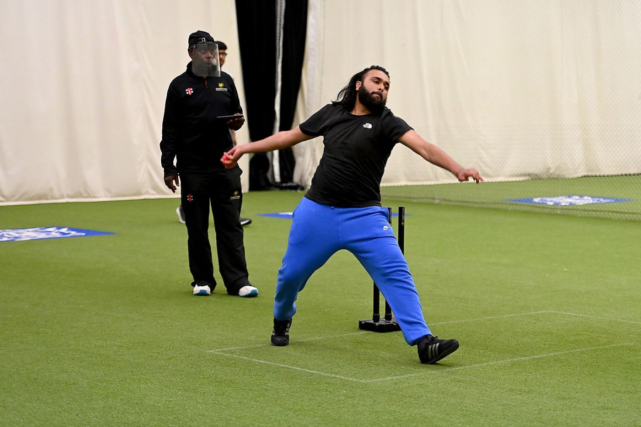 Hamza Abbas bowls as Eaton Gordon, the WCB Community Cricket Development Manager, looks on, 28 April 2021