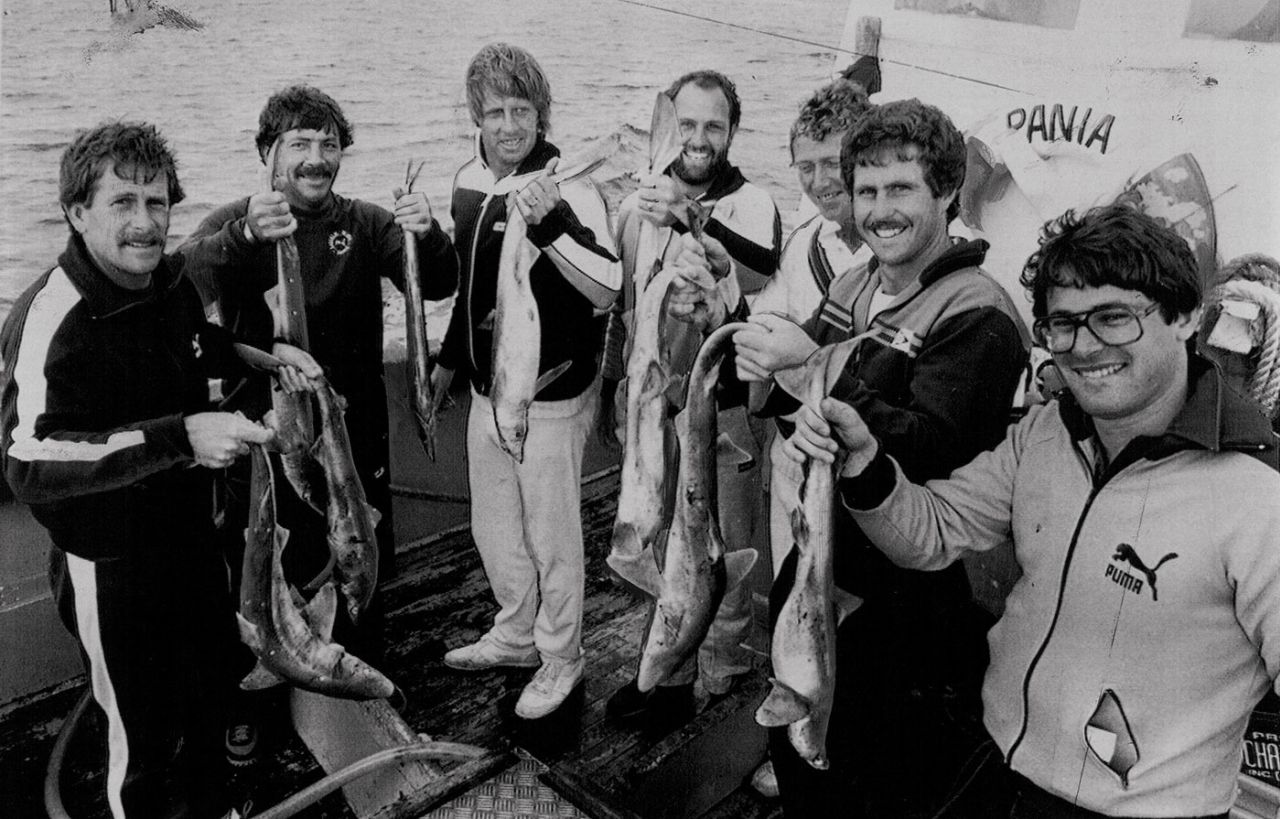 Bruce Laird, Rod Marsh, Jeff Thomson, Ray Bright, Kim Hughes, Grame Wood and the team masseur show off the catch they got at Cape Saunders, February 1982