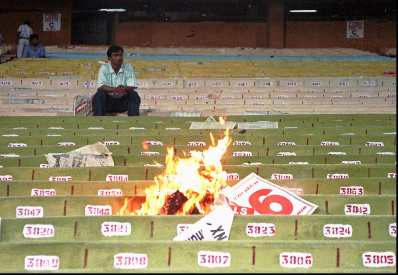 A lone fan watches the fire set by the crowd in the stands after India's poor performance against Sri Lanka, India v Sri Lanka, 1st semi-final, 1996 World Cup, Calcutta, March 13, 1996