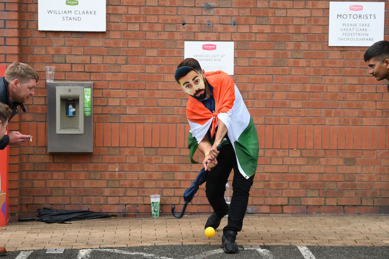 A man wearing a Virat Kohli mask bats with an umbrella as fans find innovative ways to while away time, England vs India, 1st Test, Nottingham, 5th day, August 8, 2021