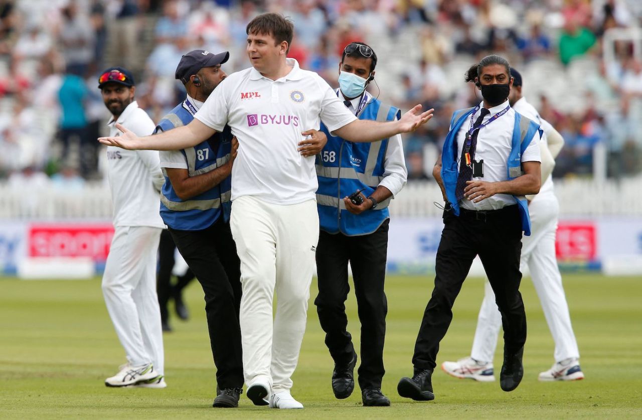 A pitch invader is escorted off the ground by security after the drinks break, England vs India, 2nd Test, Lord's, London, 3rd day, August 14, 2021