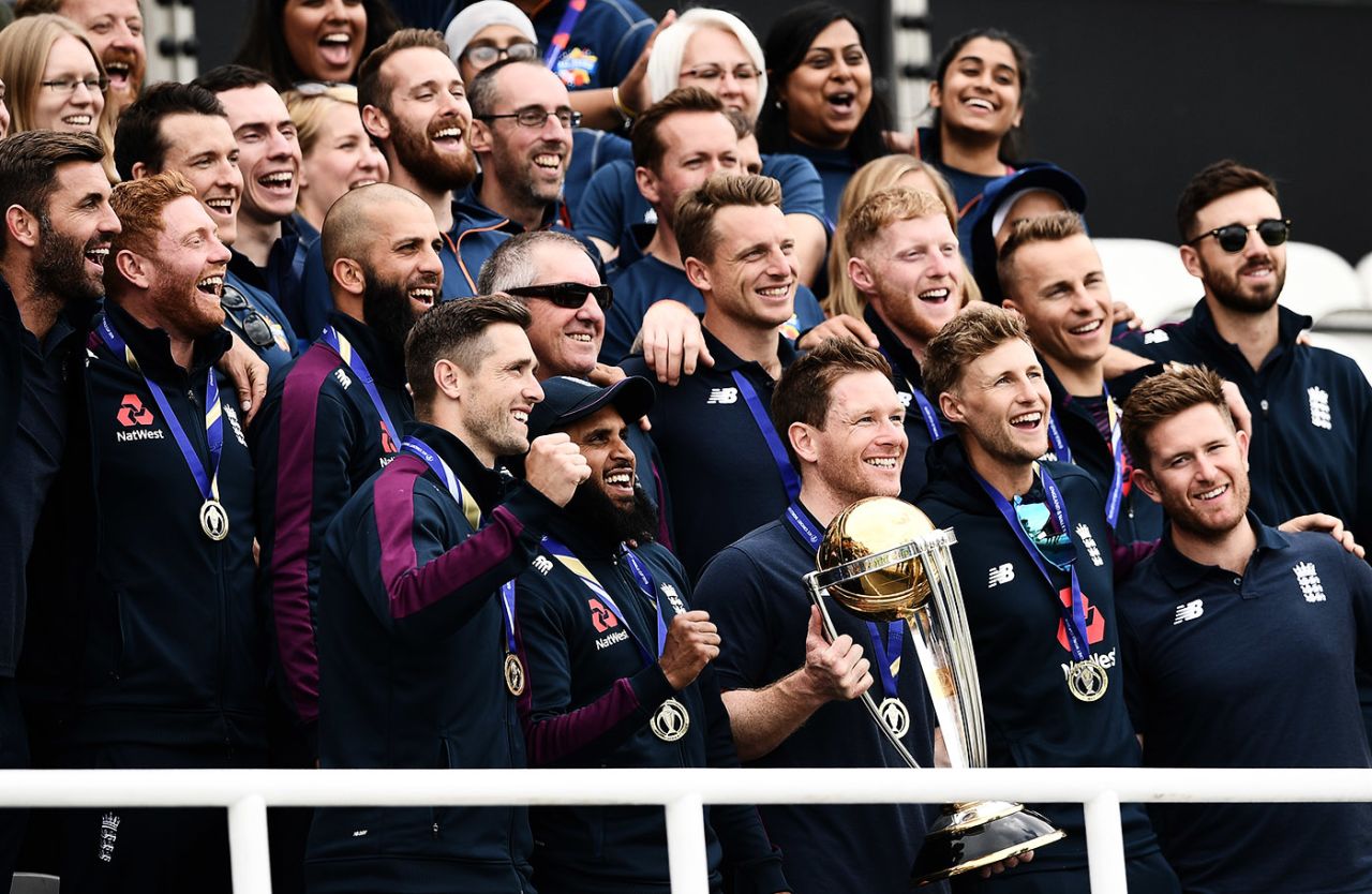 Eoin Morgan holds the World Cup surrounded by his squad, The Oval, July 15, 2019