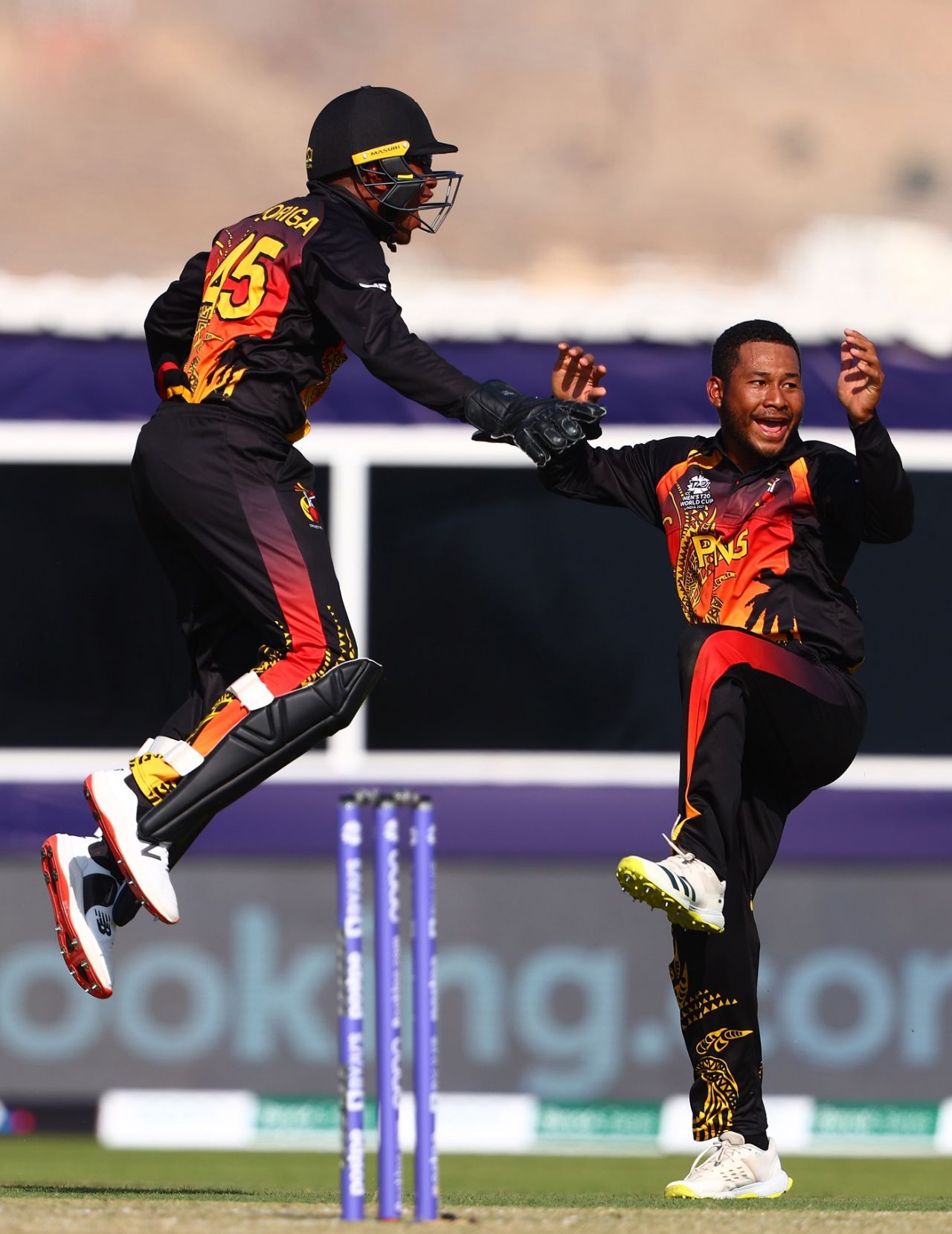Kiplin Doriga and Simon Atai leap in joy after the latter dismissed Matthew Cross, Papua New Guinea vs Scotland, T20 World Cup, Muscat, October 19, 2021