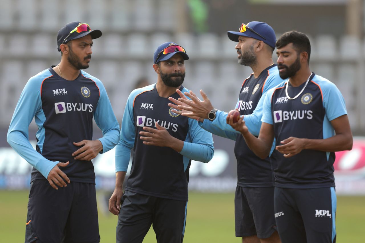 Axar Patel and Ravindra Jadeja speak to Paras Mhambrey as Mohammed Siraj gets ready for a bowl, Mumbai, December 6, 2021