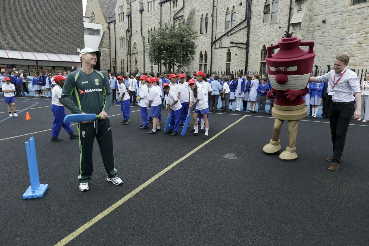 Michael Clarke laughs as an Ashes mascot is led into position for pictures during a visit to St Edward's Primary School in London, July 15, 2015