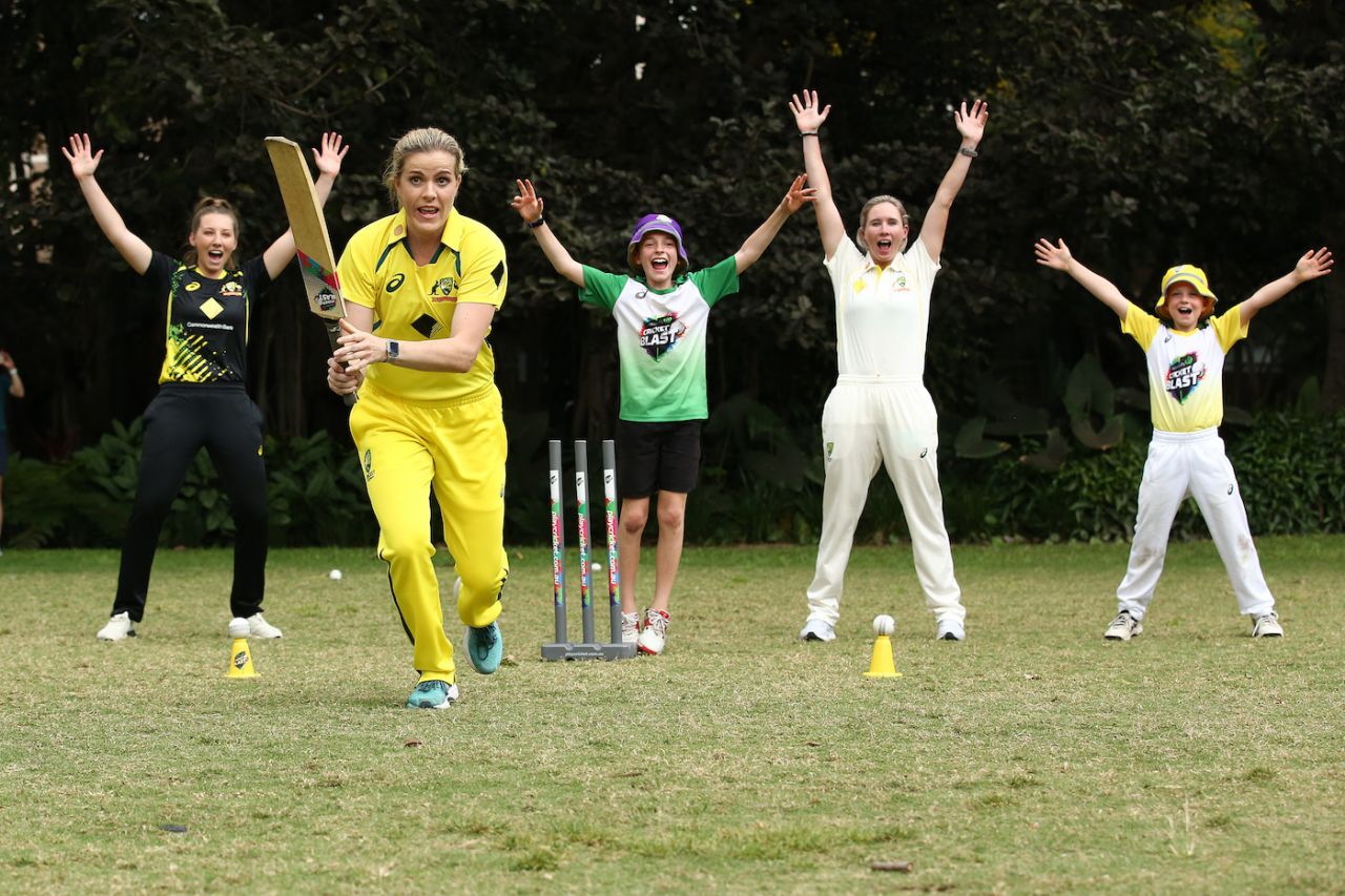 Georgia Redmayne (batting), Beth Mooney (second right), and Darcie Brown (left) play cricket with kids at the launch event for the series against India, Brisbane Botanic Gardens, Brisbane, September 13, 2021