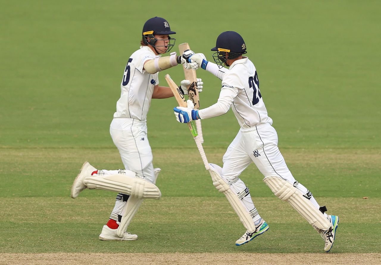Mitch Perry (left) and Todd Murphy punch gloves as the winning runs are scored, Victoria vs Tasmania, Sheffield Shield, Junction Oval, March 18, 2022